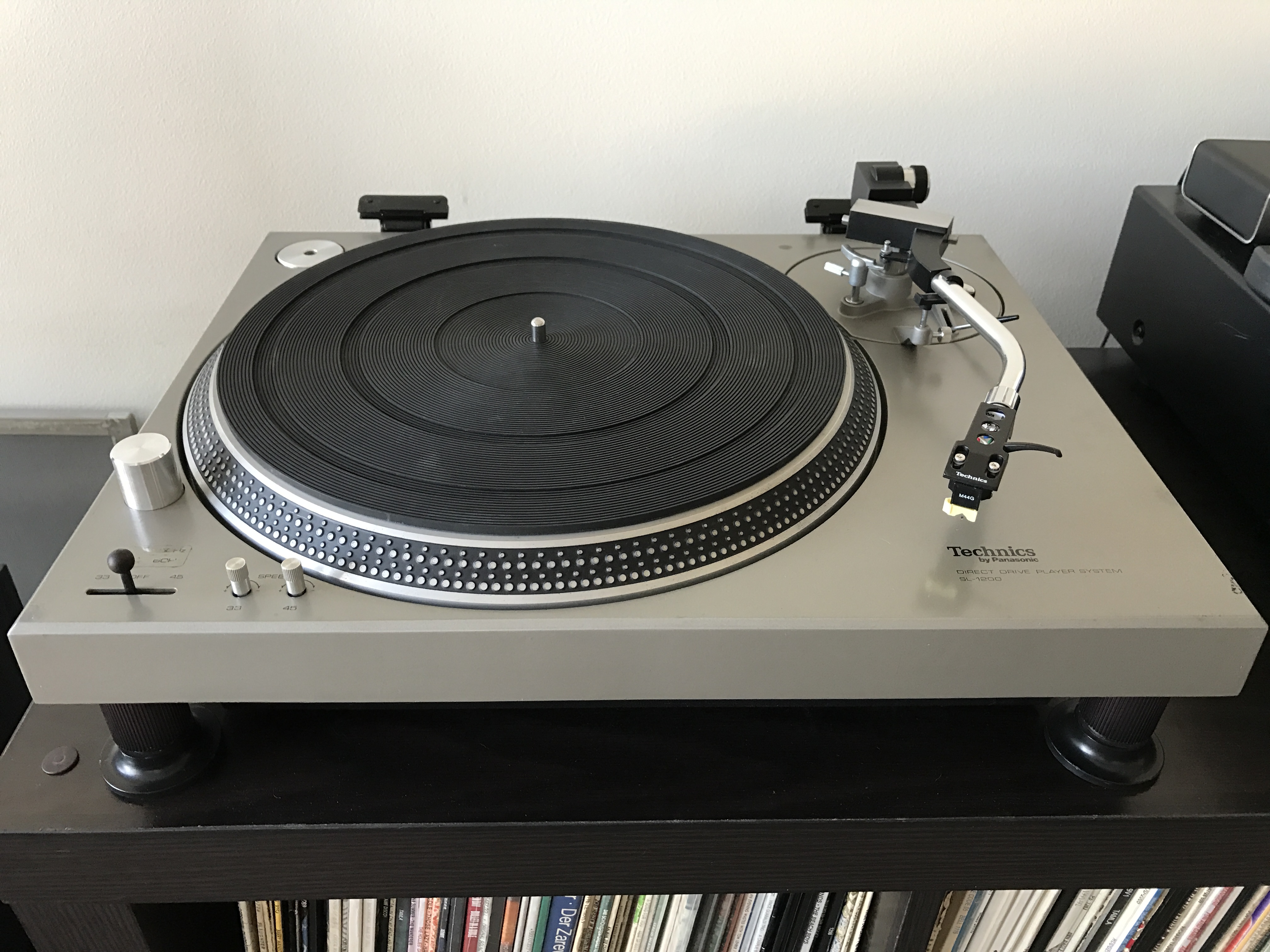 Fotografia reale di un giradischi Technics SL-1200 originale, con braccio e piatto visibili